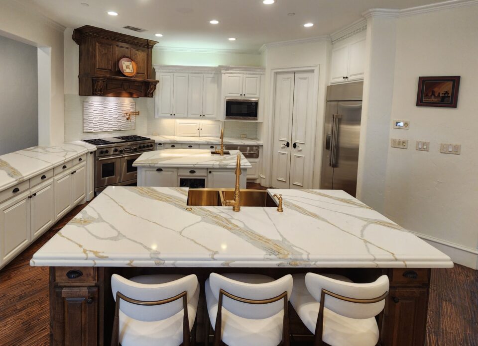 Timeless white kitchen with marble countertops, shaker style cabinets, brass fixtures, and dark wood island featuring classic design elements that never go out of style.
